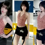 I-DLE Yuqi posing in a red and white gingham halterneck top and low-rise pants in a parking lot