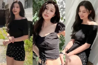 Kang Hyewon wearing a black sweetheart neckline crop top with puff sleeves on an outdoor terrace