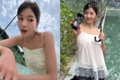 Kwon Eunbi smiling under a clear umbrella in a white slip top and black shorts