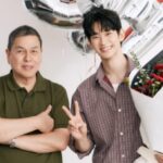 Kim Soo Hyun smiling and holding a flower bouquet with Bench CEO Ben Chan at an advertisement shoot