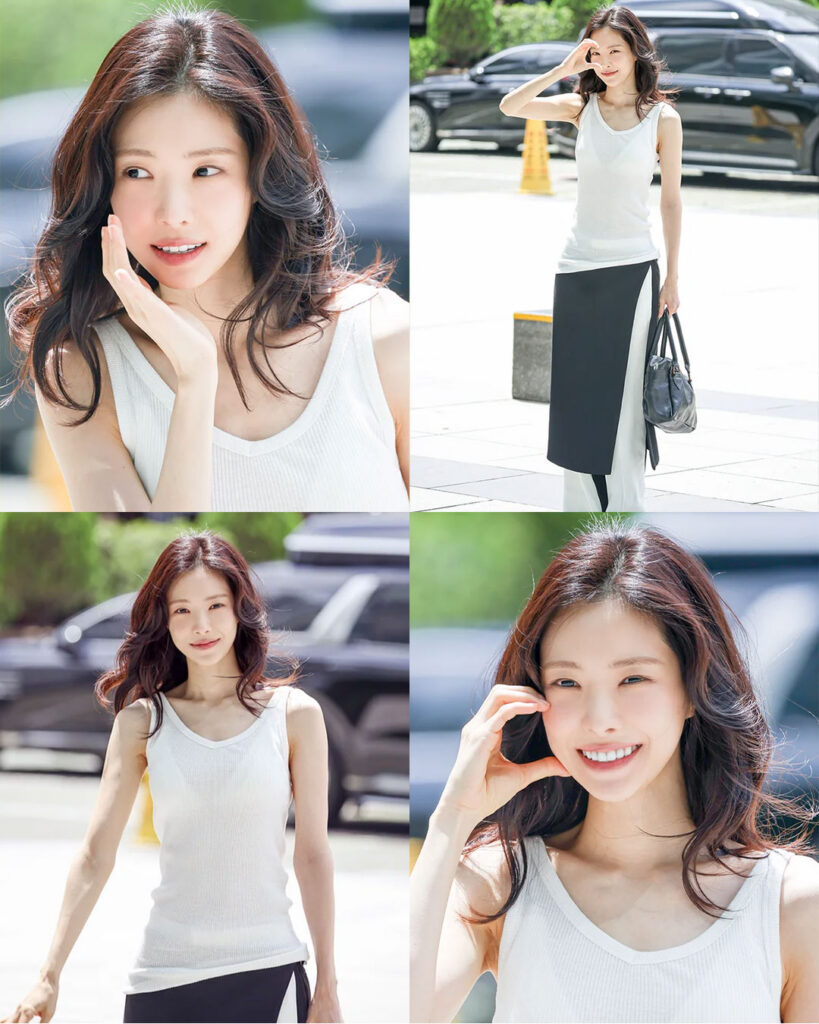 Son Naeun smiling and making a cheeky heart pose outside the SBS building