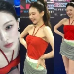 Red Velvet member Wendy posing backstage at K-Pulse Hanoi in a red halterneck top and gray skirt.