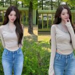 Jang Wonyoung wearing a beige halter-neck top and denim jeans at an amusement park