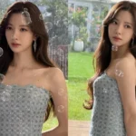 WJSN Bona posing in an off-the-shoulder dress in front of green grass