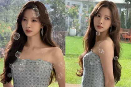WJSN Bona posing in an off-the-shoulder dress in front of green grass