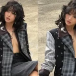 Jeon Soyeon posing in a plaid jacket and leather outfit for the Coach fashion event