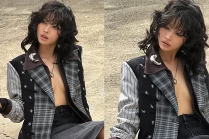 Jeon Soyeon posing in a plaid jacket and leather outfit for the Coach fashion event