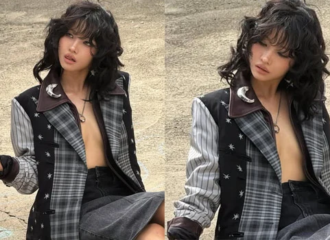 Jeon Soyeon posing in a plaid jacket and leather outfit for the Coach fashion event