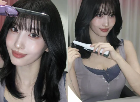 TWICE Momo holding styling tools in front of a mirror in a purple sleeveless top