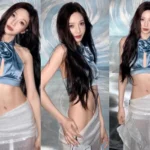Red Velvet Joy posing in a blue halter crop top and white skirt during a photoshoot