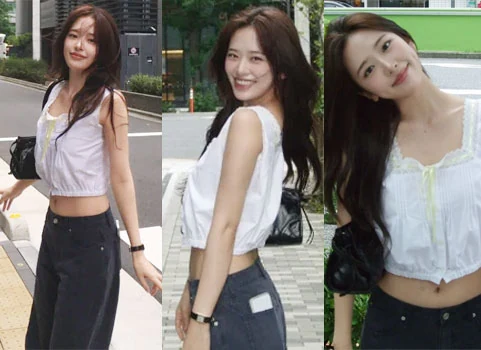 IVE An Yujin posing over-the-shoulder in a white lace crop top and blue jeans