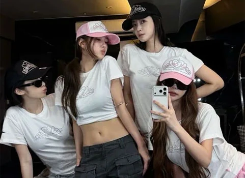 T-ara four members wearing pink and black caps posing together in a practice room for their 17th anniversary