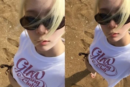 aespa Winter taking a selfie on the beach wearing sunglasses and a white t-shirt