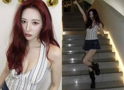 Sunmi posing on stairs in a striped halter top and denim miniskirt holding a digital camera